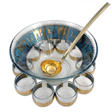 Load image into Gallery viewer, Fabulous vintage mid-century modern Carousel punch bowl with ten matching roly poly glasses and gold toned metal ladle. The glassware is decorated with carousel horses and carriages in 22kt gold on teal blue paint. Crafted by Colony, USA, circa 1960s. Perfect for serving eggnog, alcohol or non-alcohol punch at your next soirée! Stunning doesn't quite describe this fabulous set which is sure to be a standout at your next party!