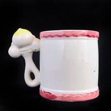 Load image into Gallery viewer, Kitschy cuteness abounds in this vintage mid-century ceramic child's mug featuring a figural baby faced rattle along with an embossed train on its track with a sweet yellow chick and pink elephant in alphabet cars, rimmed in pink scalloped borders at the top and bottom. Crafted by Rubens, Japan, circa 1950s. Such a sweet piece for a nursery and would make a lovely baby shower gift!