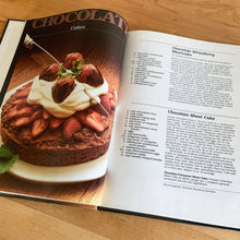 Load image into Gallery viewer, Better Homes and Gardens is known for its fabulous cookbooks. This hardcover cookbook focuses on Chocolate recipes. Its 96 pages are filled with amazing recipes along with many colour photographs. Originally published by Meredith Corporation, USA, 1984. This is the fifth printing, 1985. In great vintage condition with normal age-related yellowing.