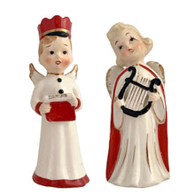 Load image into Gallery viewer, Vintage mid-century beautifully hand painted ceramic Christmas angel figurines. One, a choir boy with music song sheet and red hat and one a blonde haired girl holding a black lyre harp. Both angels wear robes of white with red trim and gold tipped wings. Made in, Japan, 1950s. These highly collectible figurines are the perfect accent for your Christmas holiday display!
Both angels are in excellent vintage condition with minor paint loss, no chips/cracks/repairs.