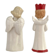 Load image into Gallery viewer, Vintage mid-century beautifully hand painted ceramic Christmas angel figurines. One, a choir boy with music song sheet and red hat and one a blonde haired girl holding a black lyre harp. Both angels wear robes of white with red trim and gold tipped wings. Made in, Japan, 1950s. These highly collectible figurines are the perfect accent for your Christmas holiday display!
Both angels are in excellent vintage condition with minor paint loss, no chips/cracks/repairs.