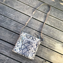 Load image into Gallery viewer, Pre-owned Ciana taupe faux python cross-body bag with adjustable strap is crafted from durable textured cow leather and features polished silver tone hardware. By Danier Leather. The zippered polyester lined interior has three compartments, one zippered pocket and metal keychain holder, one with snap closure, and one with 2-part open pocket. Exterior 2 zippered and snap closure pockets. A stylish, durable and practical accessory.