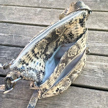 Load image into Gallery viewer, Pre-owned Ciana taupe faux python cross-body bag with adjustable strap is crafted from durable textured cow leather and features polished silver tone hardware. By Danier Leather. The zippered polyester lined interior has three compartments, one zippered pocket and metal keychain holder, one with snap closure, and one with 2-part open pocket. Exterior 2 zippered and snap closure pockets. A stylish, durable and practical accessory.