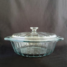 Load image into Gallery viewer, This large vintage clear glass lidded casserole dish has a distinctive scalloped design that makes cooking and serving effortless. It is oven, microwave, and dishwasher safe, making it easy to transport and reheat your favorite dishes with minimal mess. Crafted by Anchor Hocking, USA, circa 1950s, this dish is sure to bring style and convenience to your kitchen. In excellent condition, free from chips. Measures 9 inches / 23 cm Capacity 2 quarts/litres