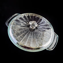 Load image into Gallery viewer, This large vintage clear glass lidded casserole dish has a distinctive scalloped design that makes cooking and serving effortless. It is oven, microwave, and dishwasher safe, making it easy to transport and reheat your favorite dishes with minimal mess. Crafted by Anchor Hocking, USA, circa 1950s, this dish is sure to bring style and convenience to your kitchen. In excellent condition, free from chips. Measures 9 inches / 23 cm Capacity 2 quarts/litres