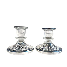 Load image into Gallery viewer, Stunning pair of vintage clear glass single lite candle holders featuring a silver overlay pattern with urn and floral scrolls. Silver City, 1950s. A romantic addition to your tablescape!
In vintage condition, the silver overlay is intact. There is a smooth chip to one piece, see photos.
Measures 4 1/4 x 4 1/4 x 3 3/4 inches