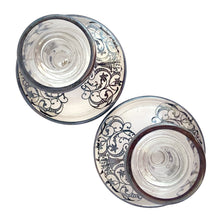 Load image into Gallery viewer, Stunning pair of vintage clear glass single lite candle holders featuring a silver overlay pattern with urn and floral scrolls. Silver City, 1950s. A romantic addition to your tablescape!
In vintage condition, the silver overlay is intact. There is a smooth chip to one piece, see photos.
Measures 4 1/4 x 4 1/4 x 3 3/4 inches