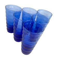 Load image into Gallery viewer, Six cobalt blue Cameron tumblers tilted at a diagonal angle, emphasizing the tall beehive silhouette and translucent blue glass