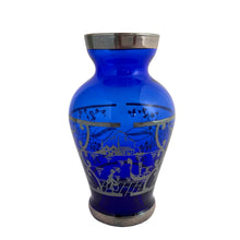 Load image into Gallery viewer, Vintage cobalt blue hand blown Murano art glass bud vase decorated with a Venetian scene and florals in silver overlay. Crafted in Italy, 1950s. A lovely piece of art glass from the mid-century, perfect for display and even sweeter with a bouquet of flowers.
In excellent condition, no chips.
Measures 2 1/2 x 2 1/2 x 4 3/4 inches