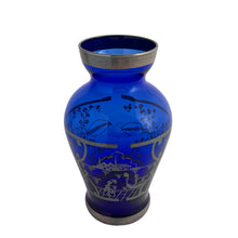 Load image into Gallery viewer, Vintage cobalt blue hand blown Murano art glass bud vase decorated with a Venetian scene and florals in silver overlay. Crafted in Italy, 1950s. A lovely piece of art glass from the mid-century, perfect for display and even sweeter with a bouquet of flowers.
In excellent condition, no chips.
Measures 2 1/2 x 2 1/2 x 4 3/4 inches
