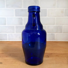 Load image into Gallery viewer, Side profile of vintage cobalt blue Luna Café glass bottle showing full height, Madera Glass Co. 1998