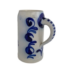 Load image into Gallery viewer, Side view of a vintage German stoneware beer stein from the handle side, showing cobalt blue floral motif, with dotted stripe handle detail and the 1L mark