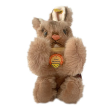 Load image into Gallery viewer, Vintage stuffed animal tan light brown bunny rabbit. Washable Dralon plush material. Hand embroidered pink nose and brown mouth, brown glass eyes with black pupils, and light beige felt rear foot pads. Gold satin ribbon and round red, blue and yellow tag bearing the name Cosy Mummy. Brass button-in-ear yellow and black tag 494020 and paper tag. Steiff, Germany 1970s. This bunny rabbit sits in a seated or reclining position. In excellent condition. Measures 8 1/2 inches or 22cm