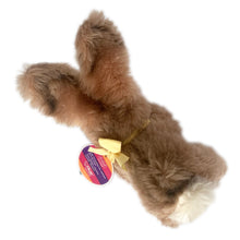 Load image into Gallery viewer, Vintage stuffed animal tan light brown bunny rabbit. Washable Dralon plush material. Hand embroidered pink nose and brown mouth, brown glass eyes with black pupils, and light beige felt rear foot pads. Gold satin ribbon and round red, blue and yellow tag bearing the name Cosy Mummy. Brass button-in-ear yellow and black tag 494020 and paper tag. Steiff, Germany 1970s. This bunny rabbit sits in a seated or reclining position. In excellent condition. Measures 8 1/2 inches or 22cm