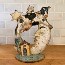 Load image into Gallery viewer, Rare early 20th century vintage The Cow Jumped Over the Moon nursery rhyme hand painted cast iron doorstop. Signed by the artist Arni on the base. This solid, one-piece diecast cut doorstop is an original free of mold seams, screws or grind marks and weighs 4 1/4 pounds. A wonderful piece of folk art to add charm to your home's decor.
In as found vintage condition with wear to the paint and rusty patina.
Measures 7 x 8 1/2 inches