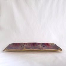 Load image into Gallery viewer, A unique hand painted Seetusee 3-part glass tray featuring shades of cranberry, blue and gold, backed with gold-toned pig skin leather. Crafted by Mayfair in Portage La Prairie, Canada, circa 1970s. These beautifully painted trays are perfect for serving candies and nuts or use as a decorative catchall. Measures 13 x 5 1/2 x 3/4 inches