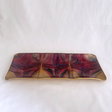 Load image into Gallery viewer, A unique hand painted Seetusee 3-part glass tray featuring shades of cranberry, blue and gold, backed with gold-toned pig skin leather. Crafted by Mayfair in Portage La Prairie, Canada, circa 1970s. These beautifully painted trays are perfect for serving candies and nuts or use as a decorative catchall. Measures 13 x 5 1/2 x 3/4 inches