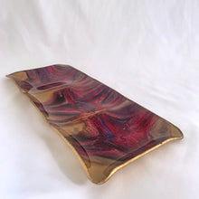 Load image into Gallery viewer, A unique hand painted Seetusee 3-part glass tray featuring shades of cranberry, blue and gold, backed with gold-toned pig skin leather. Crafted by Mayfair in Portage La Prairie, Canada, circa 1970s. These beautifully painted trays are perfect for serving candies and nuts or use as a decorative catchall. Measures 13 x 5 1/2 x 3/4 inches