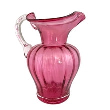 Load image into Gallery viewer, Beautiful vintage hand blown optic cranberry glass pitcher with wide wavy rim and applied glass handle. Crafted by Pilgrim Glass, USA. A stunning piece of handcrafted art glass, practical and beautiful! In excellent condition, no chips. Measures 6 x 9 1/2 inches. Capacity 64 ounces