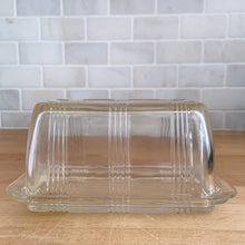 Load image into Gallery viewer, We are loving this vintage clear depression glass "Criss Cross" covered butter dish. Produced by Hazel-Atlas Glass, USA, circa 1930s. Perfect for the vintage kitchen enthusiast! In good vintage condition, lid is free from chips, interior rim of the dish flea bites. Measures 7 x 4 x 3 1/4 inches