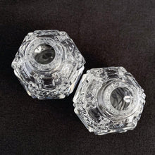 Load image into Gallery viewer, A pair of traditional vintage round paneled shaped cut crystal salt and pepper shakers in the art deco style featuring an "X" and diamond pattern with sterling silver mother-of-pearl lids.   In excellent condition, no chips or cracks. Marked 925 Sterling.  Measures 1 1/2 x 1 3/4 inches
