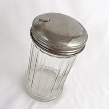 Load image into Gallery viewer, Bring the nostalgia of classic restaurant diners to your table with this vintage pressed glass sugar dispenser, featuring clear vertical panels and a chrome lid. Crafted by Halco USA. Add a timeless touch to your kitchen coffee/tea station! In excellent condition, free from chips with only minor wear on the lid. Measure 3 x 5 3/4 inches