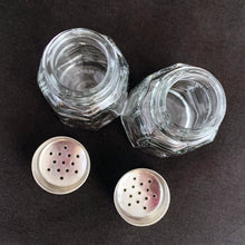 Load image into Gallery viewer, Sail away to flavor-town with this retro vintage set of salt and pepper shakers! These 50s-style shakers come with stylish clear pressed glass panels and stainless steel screw-on lids. Season your food with a real blast from the past! The glass is in excellent condition, free from chips/cracks. The lids have very minor wear, see photos. Marked "MEXICO". Measures 1 3/8 x 3 inches