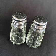 Load image into Gallery viewer, Sail away to flavor-town with this retro vintage set of salt and pepper shakers! These 50s-style clear pressed glass shakers come feature eight panels and flat top stainless steel screw-on lids. Season your food with a real blast from the past! The glass is in excellent condition, free from chips/cracks. The lids have very minor wear, see photos. Marked "TAIWAN". Measures 1 3/8 x 3 inches
