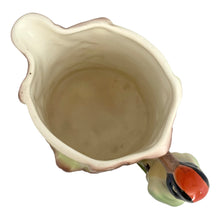 Load image into Gallery viewer, Overhead and interior view of vintage Czech Majolica woodpecker pitcher showing glazed cream interior and organic shaped rim with bird handle at bottom