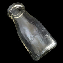 Load image into Gallery viewer, Angled view of Donlands Dairy 8 oz Clear Glass Cream Bottle show Donlands embossed logo. Bottle made by Dominion Glass Canada circa 1950s