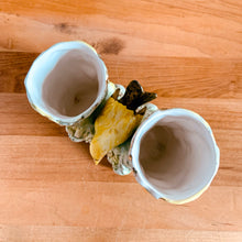 Load image into Gallery viewer, Once can't help but smile at this adorable pale green double tree trunk vase with sweet yellow bird perched in the middle and gold gilt details. This vessel is perfect for creating a small floral bouquet or simply display it amongst your treasures. Produced by Ucagco, Japan, circa 1950s. In excellent condition, free from chips/cracks/repairs. Marked Japan on the bottom. Measures 5 1/8 x 3 x 4 1/4 inches