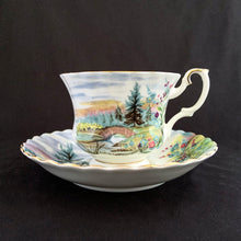 Load image into Gallery viewer, This vintage bone china footed teacup and saucer is so sweet! Both the cup and saucer are decorate with the "Dovedale" pattern from the Country Scenes series. Each piece has a lovely scalloped edge with hand painted whimsical country scene, trimmed with gold gilt. Produced by Royal Albert, England, circa 1917 - 1927. In excellent condition, free from chips, cracks and repairs. Maker's marks are on the bottom. Teacup measures 3 3/8 x 2 3/4 inches | Saucer measures 5 1/2 inches