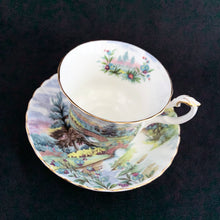 Load image into Gallery viewer, This vintage bone china footed teacup and saucer is so sweet! Both the cup and saucer are decorate with the "Dovedale" pattern from the Country Scenes series. Each piece has a lovely scalloped edge with hand painted whimsical country scene, trimmed with gold gilt. Produced by Royal Albert, England, circa 1917 - 1927. In excellent condition, free from chips, cracks and repairs. Maker's marks are on the bottom. Teacup measures 3 3/8 x 2 3/4 inches | Saucer measures 5 1/2 inches