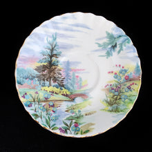 Load image into Gallery viewer, This vintage bone china footed teacup and saucer is so sweet! Both the cup and saucer are decorate with the "Dovedale" pattern from the Country Scenes series. Each piece has a lovely scalloped edge with hand painted whimsical country scene, trimmed with gold gilt. Produced by Royal Albert, England, circa 1917 - 1927. In excellent condition, free from chips, cracks and repairs. Maker's marks are on the bottom. Teacup measures 3 3/8 x 2 3/4 inches | Saucer measures 5 1/2 inches