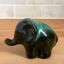 Load image into Gallery viewer, Blue Mountain Pottery elephant figurine, side view — forest green drip glaze, trunk raised, standing pose, "African Lion Safari" gold script on back