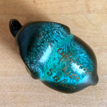 Load image into Gallery viewer, Overhead view of Blue Mountain Pottery elephant figurine back — "African Lion Safari" gold lettering detail on green drip-glazed ceramic surface