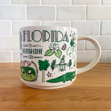 Load image into Gallery viewer, Perfect for your morning cuppa joe! This fabulous collectible FLORIDA ceramic mug was produced by Starbucks as part of their "Been There Series" Across The Globe Collection, 2017. A white ceramic mug printed design in shades of pink and green with pink interior. Celebrate the sunshine state! In excellent condition, free from chips/cracks/wear. Measures 3 5/8 x 3 3/8 inches Capacity 14 ounces