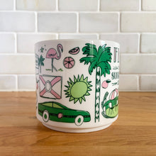 Load image into Gallery viewer, Perfect for your morning cuppa joe! This fabulous collectible FLORIDA ceramic mug was produced by Starbucks as part of their "Been There Series" Across The Globe Collection, 2017. A white ceramic mug printed design in shades of pink and green with pink interior. Celebrate the sunshine state! In excellent condition, free from chips/cracks/wear. Measures 3 5/8 x 3 3/8 inches Capacity 14 ounces