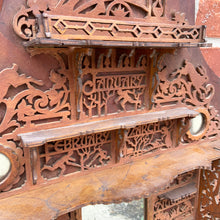 Load image into Gallery viewer, Incredible primitive antique Father Time handmade wood scroll saw wall hung shelf depicting the months of the year with scenes of figures, flora and fauna including birds, rabbits and flowers depicting an activity appropriate to the month, topped with a lounging Father Time with sycthe and hourglass. There are a total of 10 shelves which are notched together and removable, in addition there are 4 mirrors. In as found condition with a corder of the backboard damaged.