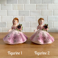 Load image into Gallery viewer, This sweet vintage mid-century figurine is one of the Birthday of the Month series designed by Josef Originals, Japan, 1950s. This sweet black-eyed girl is beautifully styled wearing a full length gown, hand painted in purple with raised flowers, holding a purple flowers with an amethyst birthstone in the centre of the flower. In excellent condition, free from chips/cracks/repairs. Marked on the bottom with the Noritake for Giftcraft mark. Measures 3 1/2 x 4 inches