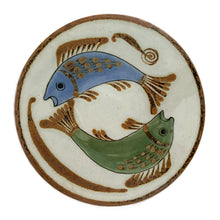 Load image into Gallery viewer, A charming hand painted folk art trivet featuring a whimsical fish design. Crafted by Ken Edwards, La Palomar Pottery, Tonalá, Mexico 1960s. This vintage ceramic piece brings artisanal character to your kitchen while protecting surfaces from heat. Perfect for displaying hot dishes, pots, and pans with a touch of Mexican flair.
In excellent condition, no chips.
Measures 7 3/8 x 1/4 inches