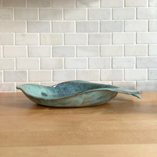 Load image into Gallery viewer, This one-of-a-kind studio art pottery figural fish dish is an exquisite example of artisan craftsmanship. Glazed in an aqua and blue with a textured surface, it's a stunning piece that will bring a splash of beauty to your home. Signed by the artist with the initials "JF," it's perfect for showing off candies and other treats or just adding a touch of beauty to your decor. In excellent condition, free from chips/cracks/repairs. Measures approximately 13 3/4 x 11 x1 3/4 inches