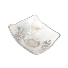 Load image into Gallery viewer, Vintage Flanders clear candy bowl features a silver overlay pattern of poppy flowers. The blank is Viking Glass and the overlay is by Silver City Glass, USA, 1940s. his lovely square bowl with folded corners is perfect for serving candies or to use as a catchall. A lovely way to add a touch of vintage charm to your home or to give as housewarming or wedding gift.
In excellent condition, no chips. Silver is intact.
Measures 6 x 3 inches