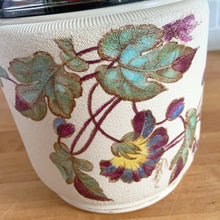 Load image into Gallery viewer, Antique porcelain biscuit jar featuring whimsical florals on a cream ground with silver plated collar, handle and lid. Crafted by Taylor Tunnicliffe, England, 1875 - 1898. Absolutely stunning example of decorative and functional artistry from the Aesthetic Movement era! In overall excellent condition for a piece of its age with wear to the silver plate on the lid and minor discolouration on the porcelain. Measures 5 x 6 5/8 inches (8 1/4 with handle raised)