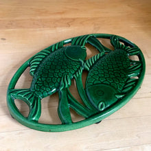 Load image into Gallery viewer, Vintage oval cast iron trivet in forest green enamel with fish motif, front view — Home Essentials, Taiwan, 1970s