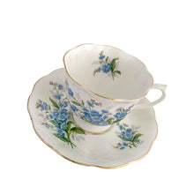 Load image into Gallery viewer, Vintage Avon shaped Forget-Me-Not bone china teacup and saucer, features a scalloped edge with hand painted blue flowers and gold gilt rim. Royal Albert, England, 1950s. In excellent condition, free from chips, cracks and repairs. Makers marks present. Teacup measures 3 1/4 x 2 3/4 inches | Saucer measures 5 1/2 inches