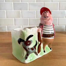 Load image into Gallery viewer, Rare vintage colourful ceramic planter featuring a gentleman hunter sporting a red cap and plaid hunting jacket gun and adorable hunting dog. Crafted by R/P, Japan, circa 1950s. An unique piece to add to your planter or hunting collection! In excellent condition, no chips/cracks/repairs. Rifle end missing and could easily be replaced with a piece of metal Measures 5 x 2 7/8 x 5 1/4 inches