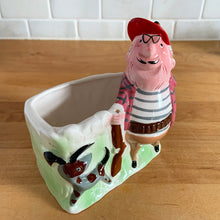 Load image into Gallery viewer, Rare vintage colourful ceramic planter featuring a gentleman hunter sporting a red cap and plaid hunting jacket gun and adorable hunting dog. Crafted by R/P, Japan, circa 1950s. An unique piece to add to your planter or hunting collection! In excellent condition, no chips/cracks/repairs. Rifle end missing and could easily be replaced with a piece of metal Measures 5 x 2 7/8 x 5 1/4 inches