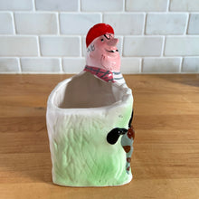 Load image into Gallery viewer, Rare vintage colourful ceramic planter featuring a gentleman hunter sporting a red cap and plaid hunting jacket gun and adorable hunting dog. Crafted by R/P, Japan, circa 1950s. An unique piece to add to your planter or hunting collection! In excellent condition, no chips/cracks/repairs. Rifle end missing and could easily be replaced with a piece of metal Measures 5 x 2 7/8 x 5 1/4 inches