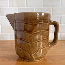 Load image into Gallery viewer, Vintage gloss brown stoneware pitcher with stacked chevron detail. Crafted by Monmouth Western Stoneware, USA, 1920s. Add this utilitarian piece to your farmhouse decor or art pottery collection!
In excellent vintage condition, no chips/cracks/repairs, age-related crazing. Unmarked.
Measures 4 1/2 x 5 inches
